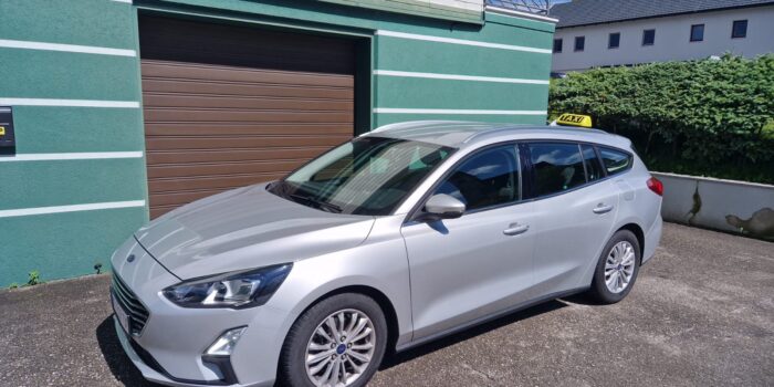 Modernes Taxi von Nusstaxi auf einer kleinen Straße in Kirchdorf an der Krems
